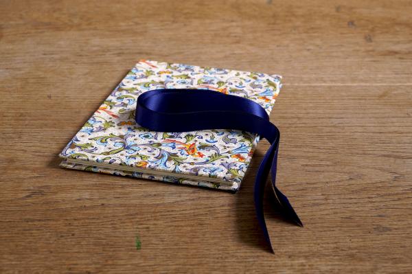 Small photo album with birds of paradise and colorful ornaments, blue satin bow